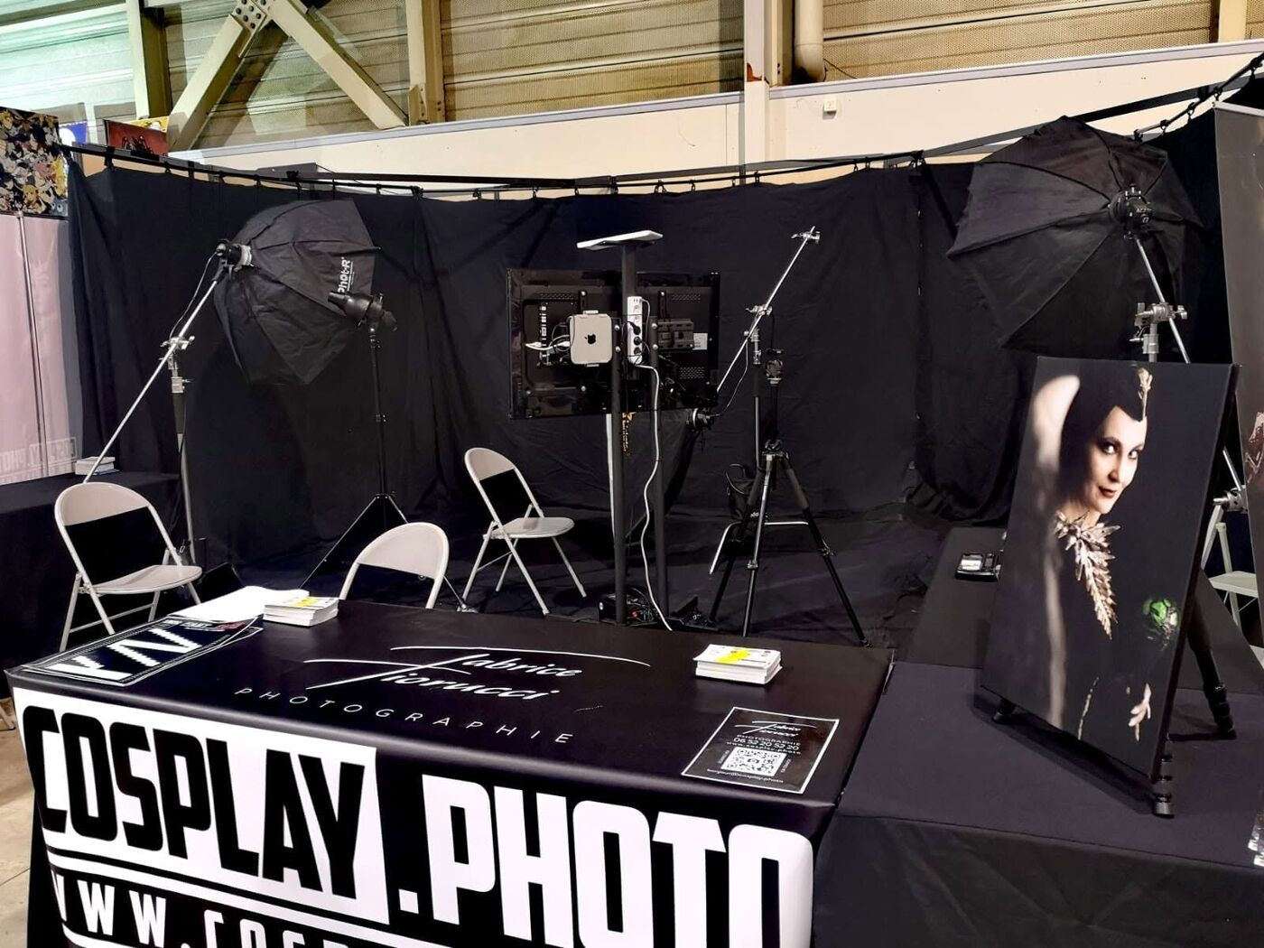 Le stand cosplay.photo au HeroFestival Marseille : fond noir, flashs, écran et table d'accueil