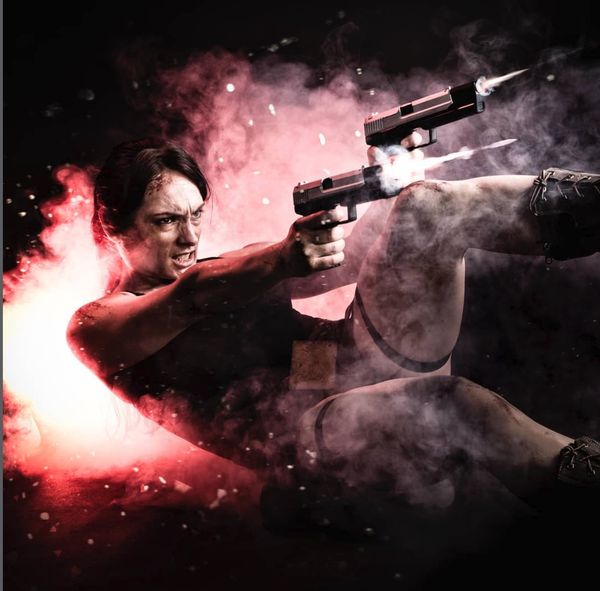 Cosplay Lara Croft (Tomb Raider), double pistolet en action sous fumée rouge — Fabrice Fiorucci Photographe